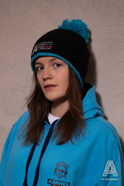 black and blue wool hat with Alpenwelt, Susi Alm, and Hannes Alm logo patch