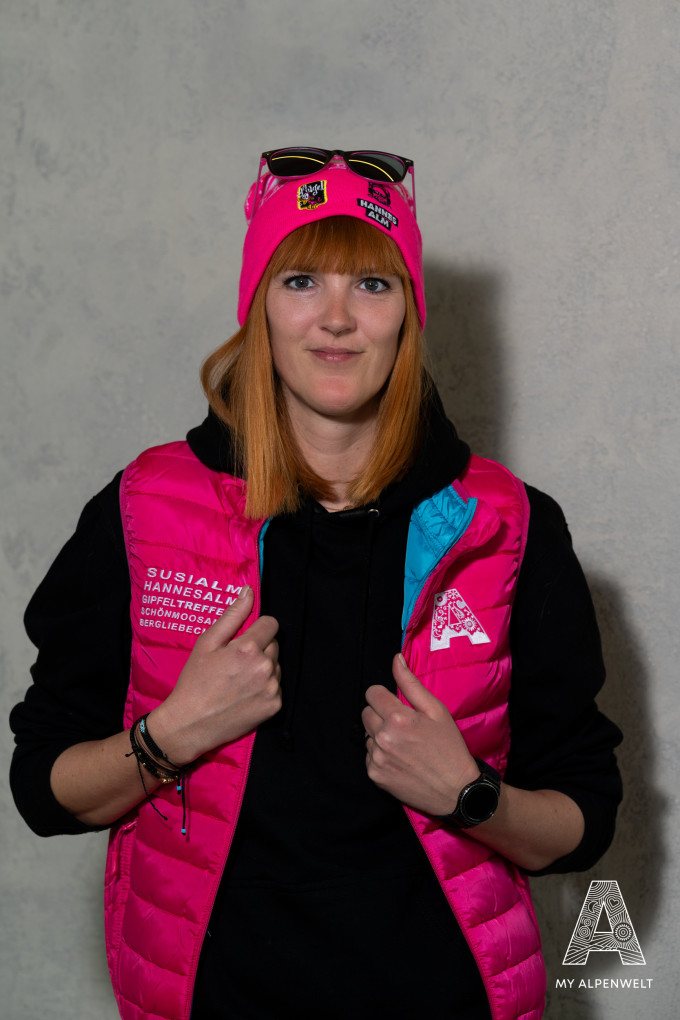 Vest blue on the inside, pink on the outside, A logo on the front left, company name on the front right