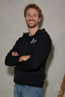 Black zipper jacket with hood. Hannes Alm and Susi Alm logo on the front left.