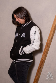 schwarz-weiße College Jacke: Alpenwelt Logo vorne Links, Bergliebe.Rocks Schrift Zug am linken Ärmel