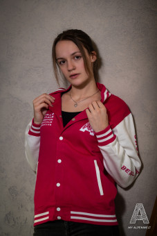 Pink and white college jacket: Alpenwelt logo on the front left, Bergliebe.Rocks lettering on the left sleeve